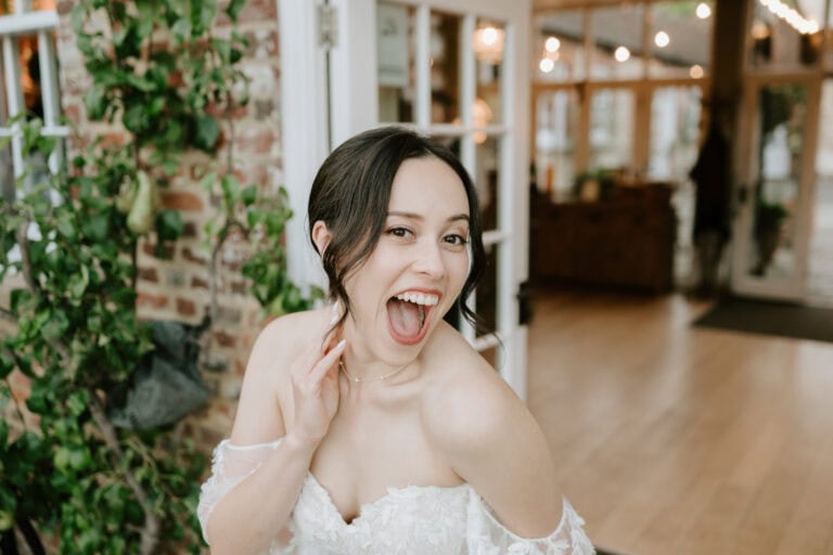 Happy bride in wedding dress indoors.