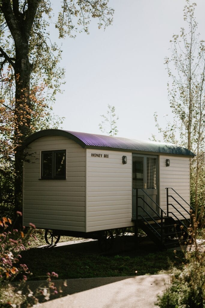 Shepherd's hut named Honey Bee in sunlight.