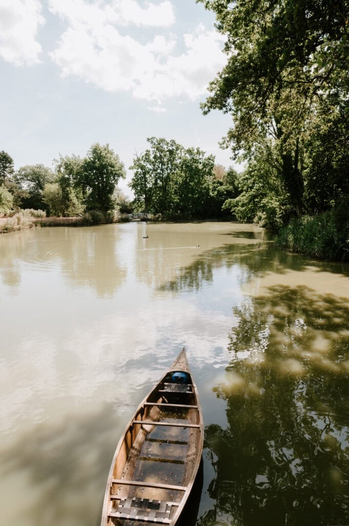 Wooden boat on serene lake with trees reflection.