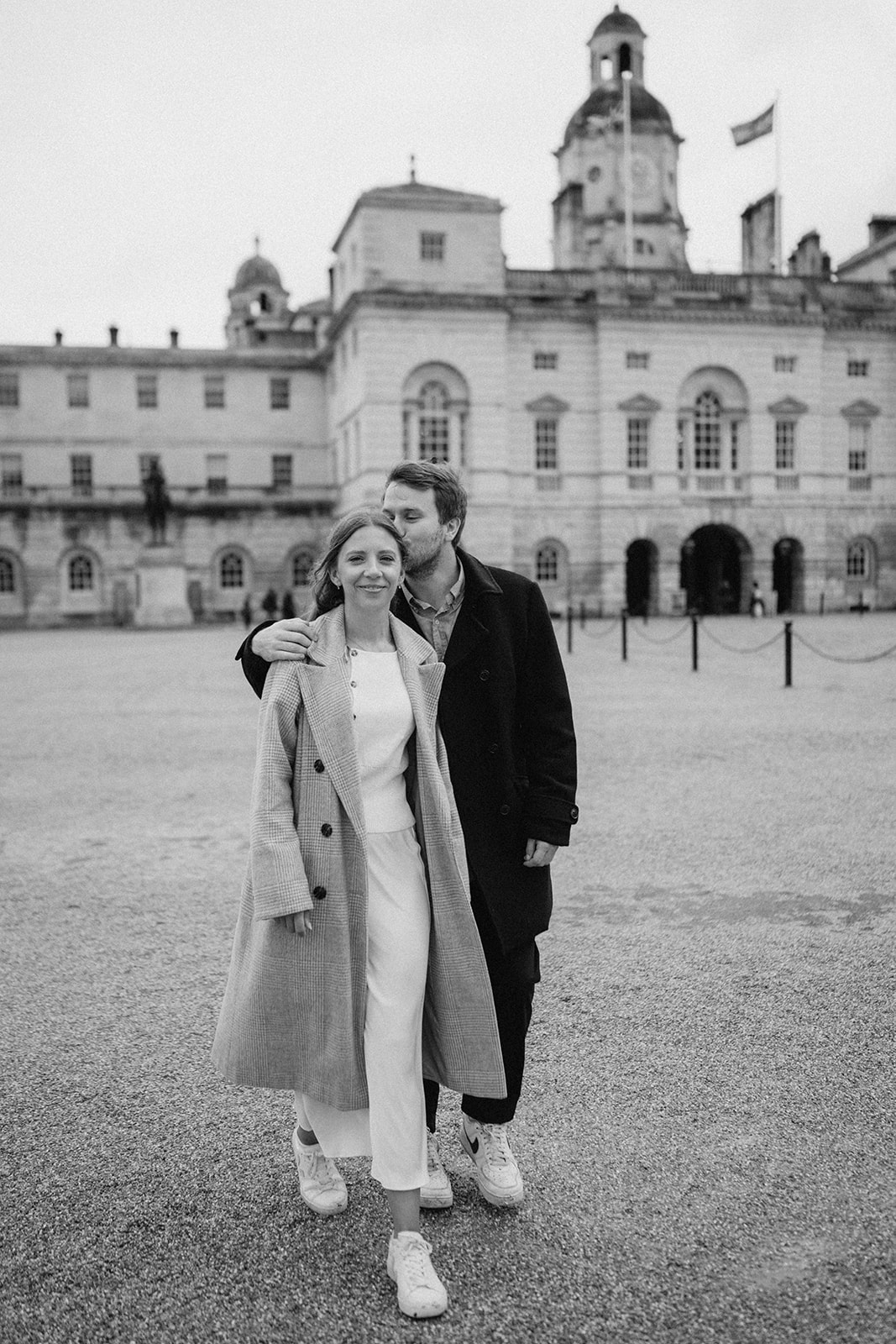 Couple walking by historic building in London.