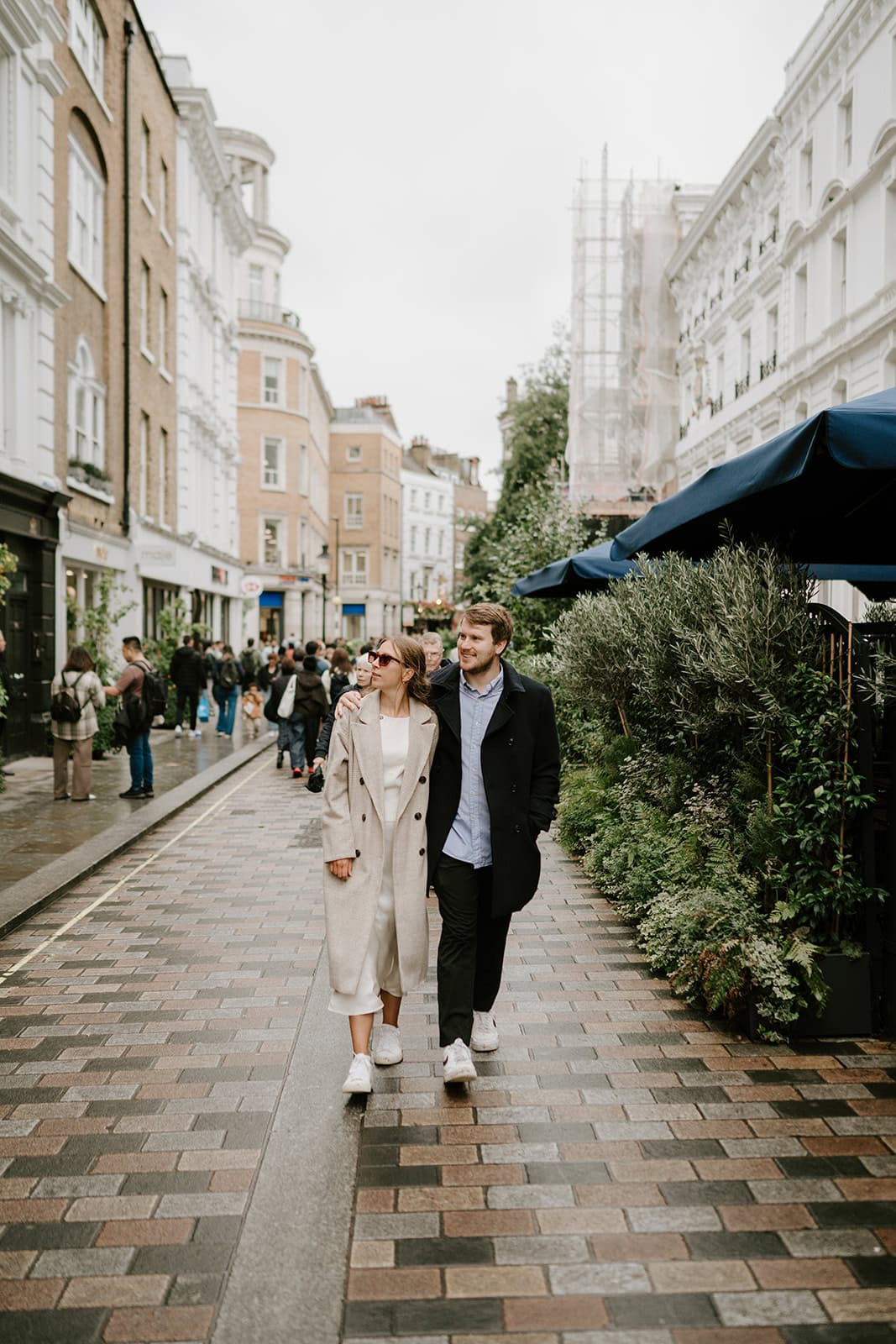 Couple walking down a leafy city street
