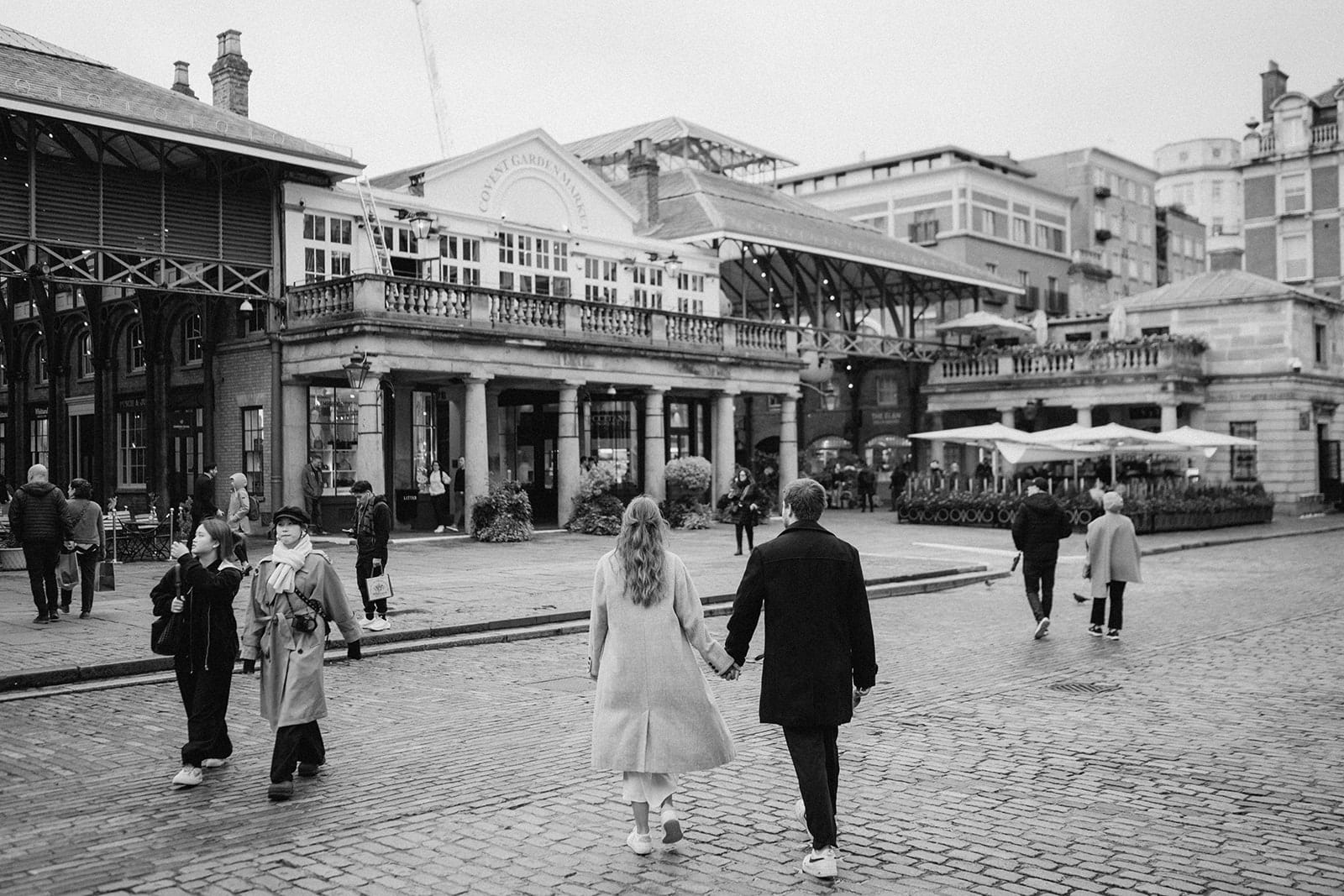 Couple walking in Covent Garden, London.