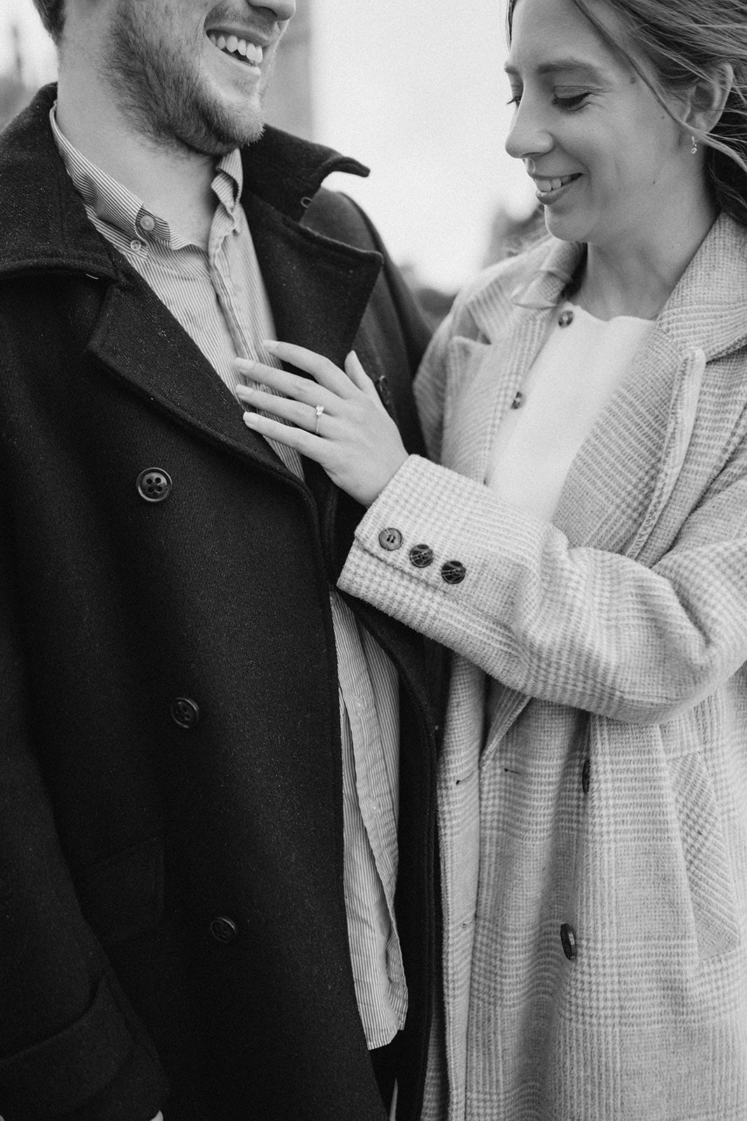 Couple smiling, woman touching man's coat