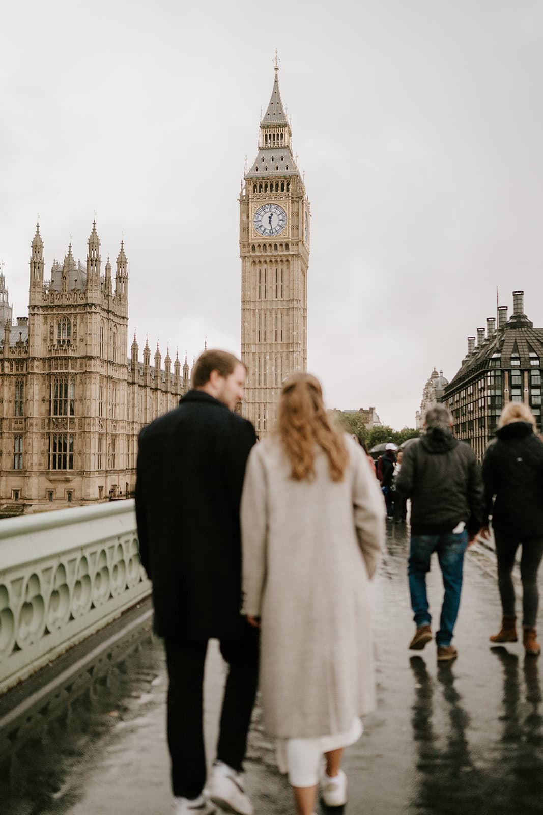 People walking near Big Ben on rainy day.