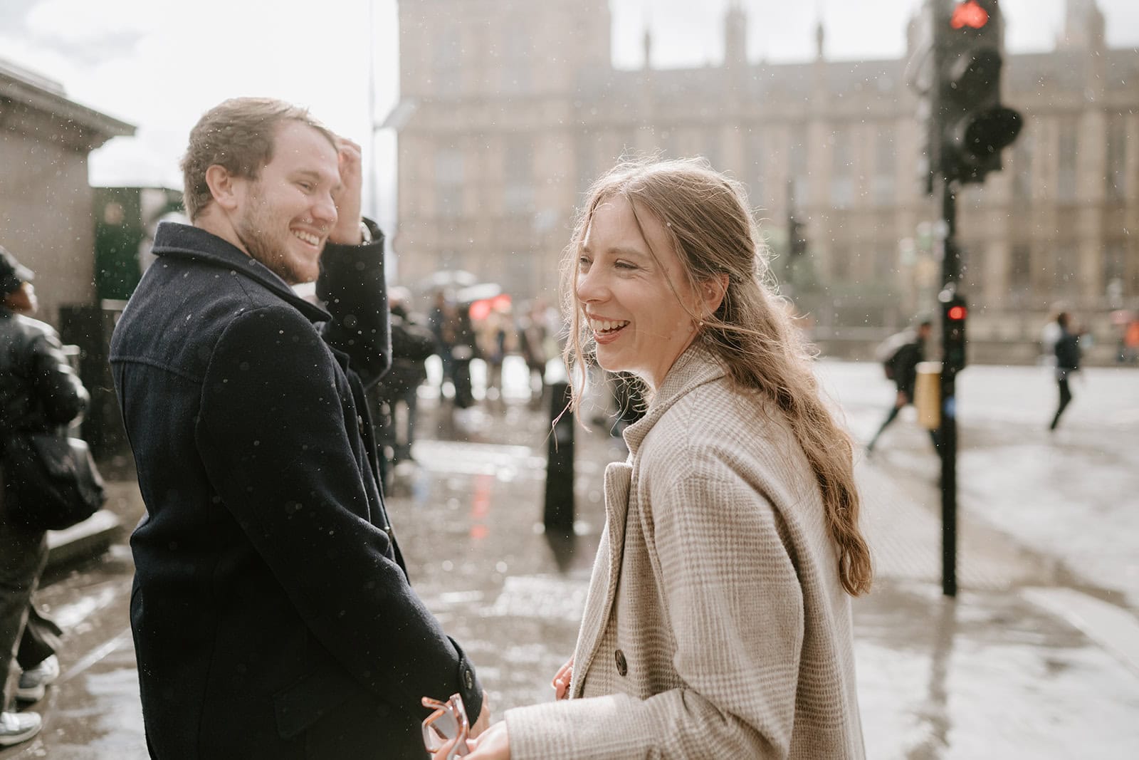 Couple laughing in rainy London street