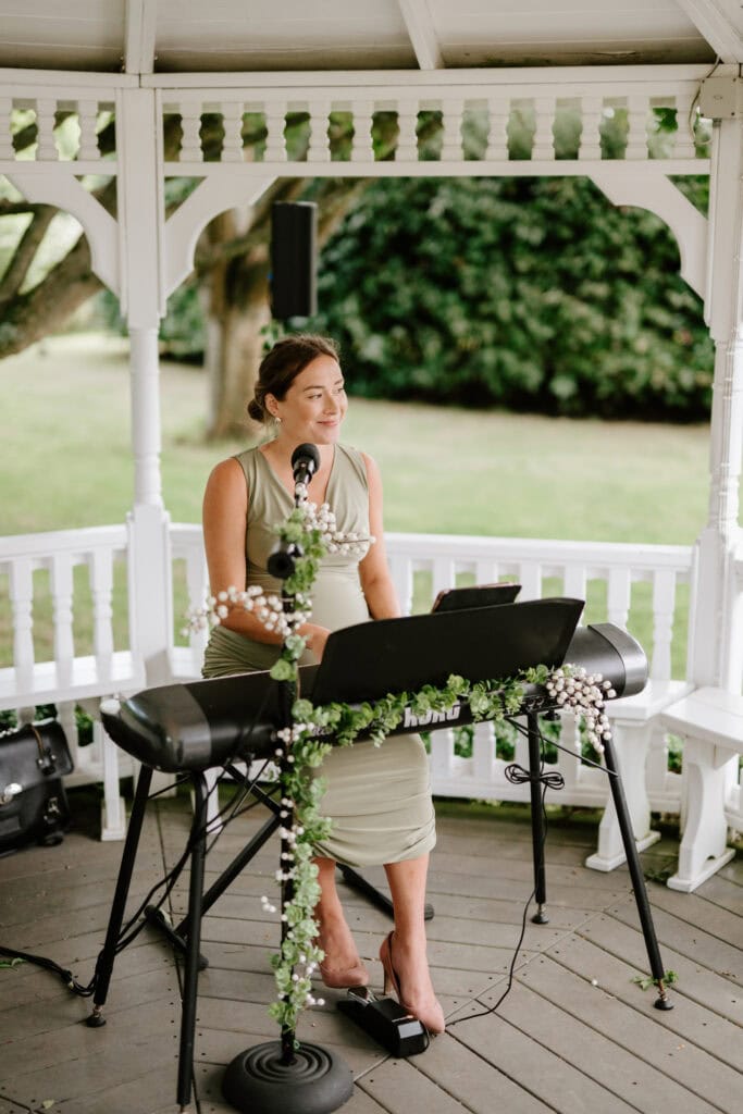 Woman playing keyboard in garden gazebo