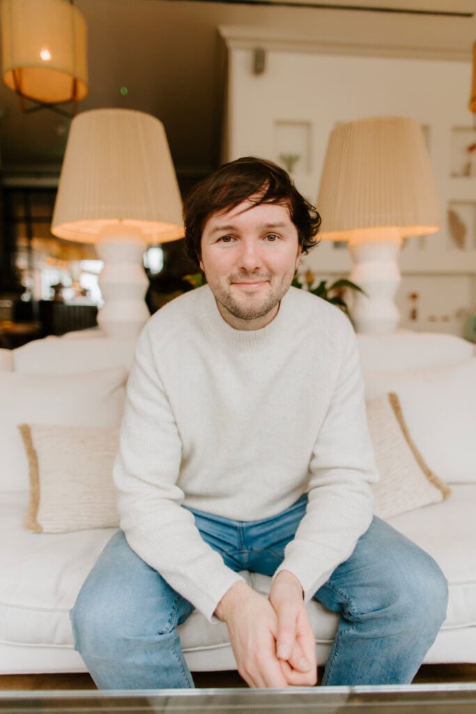 james pearce sitting on a white sofa indoors