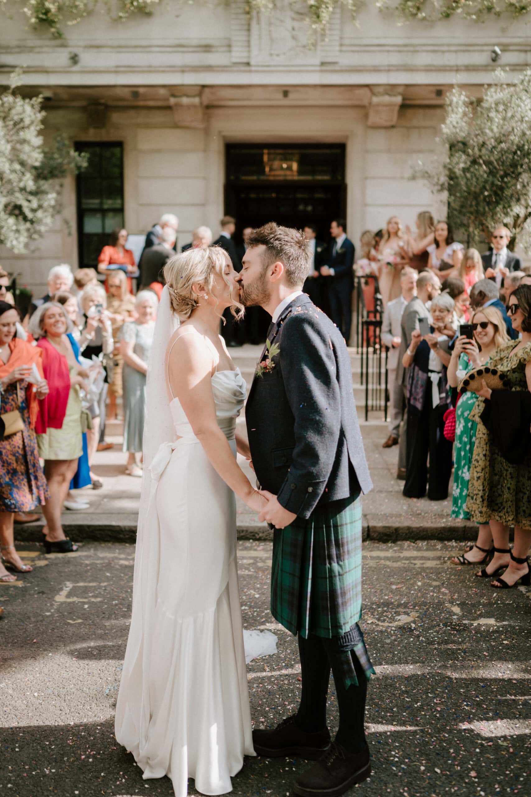 Bride and groom kiss at wedding ceremony.