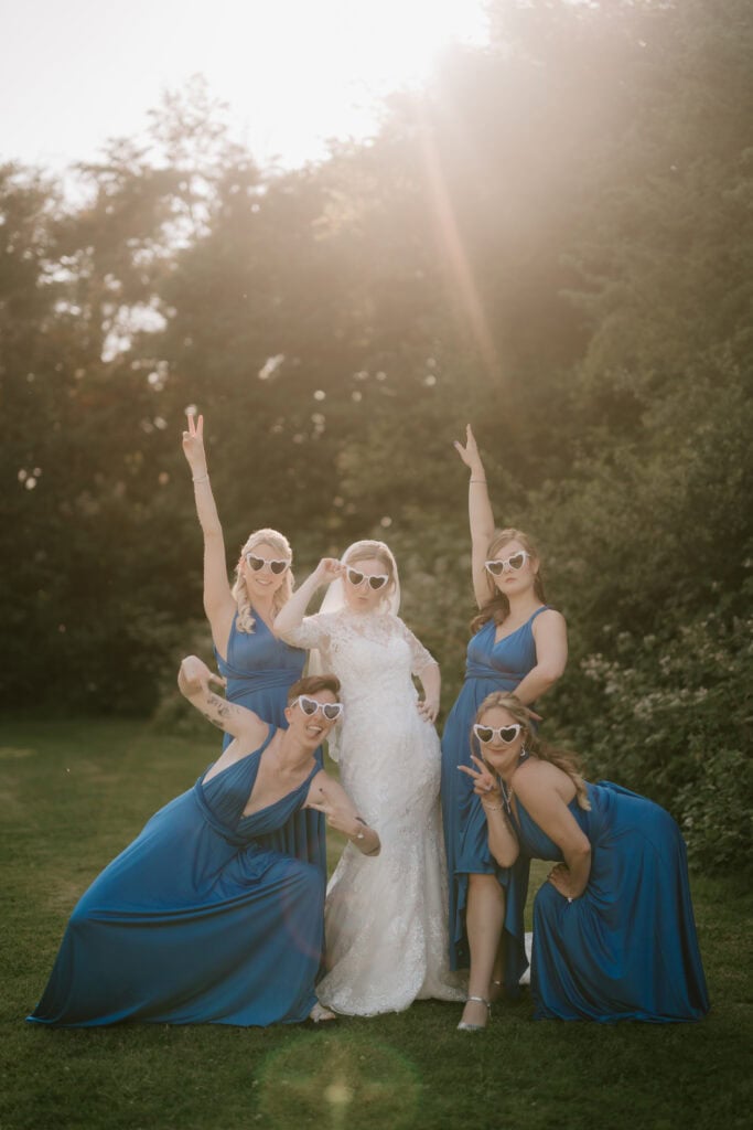 Bride and bridesmaids posing with heart-shaped sunglasses.