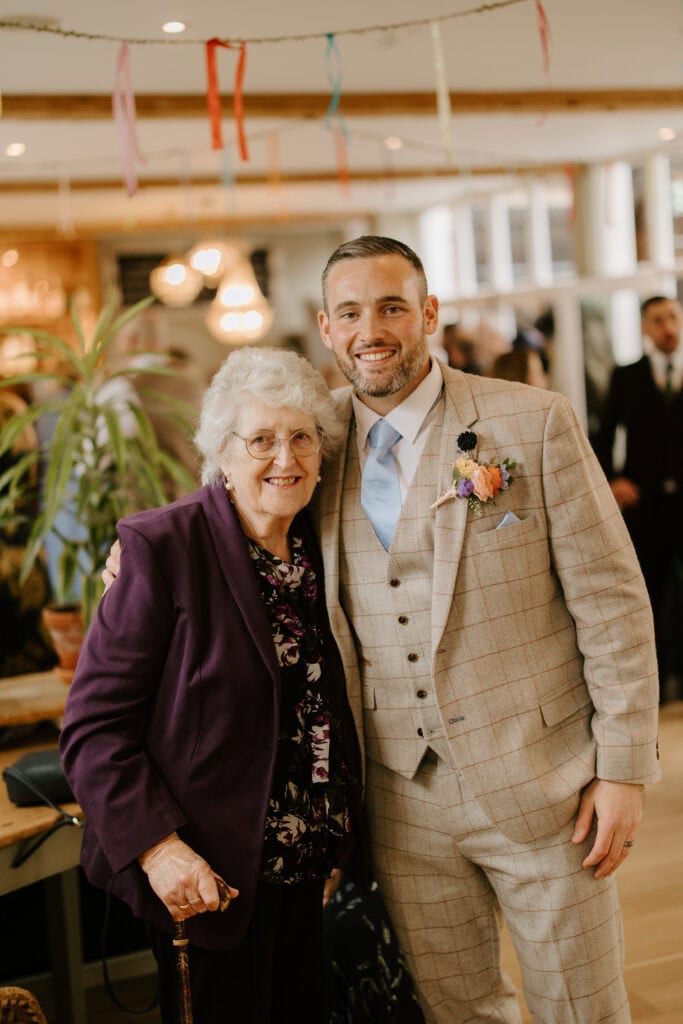 Smiling elderly woman with man in suit, indoors.