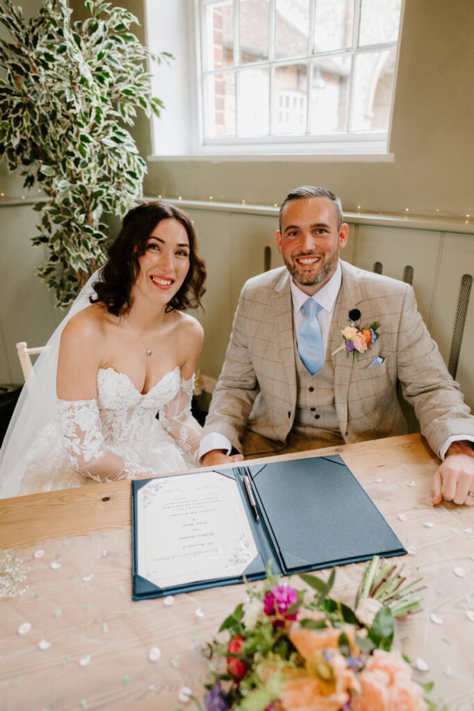 Bride and groom signing wedding register.