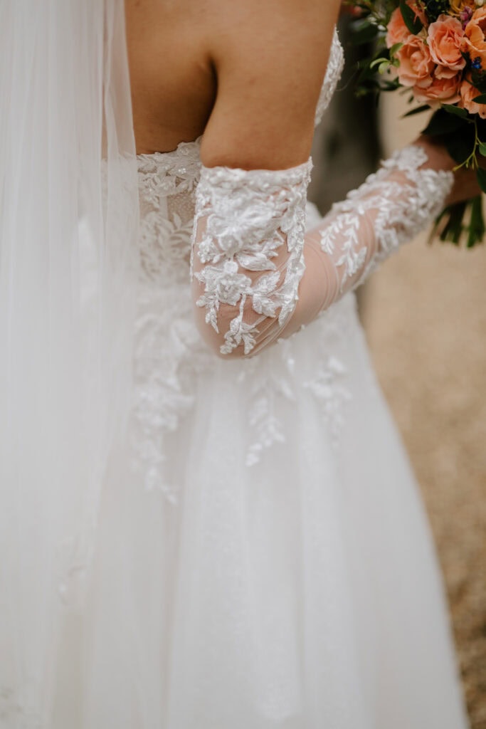 Bride in lace wedding dress holding bouquet.