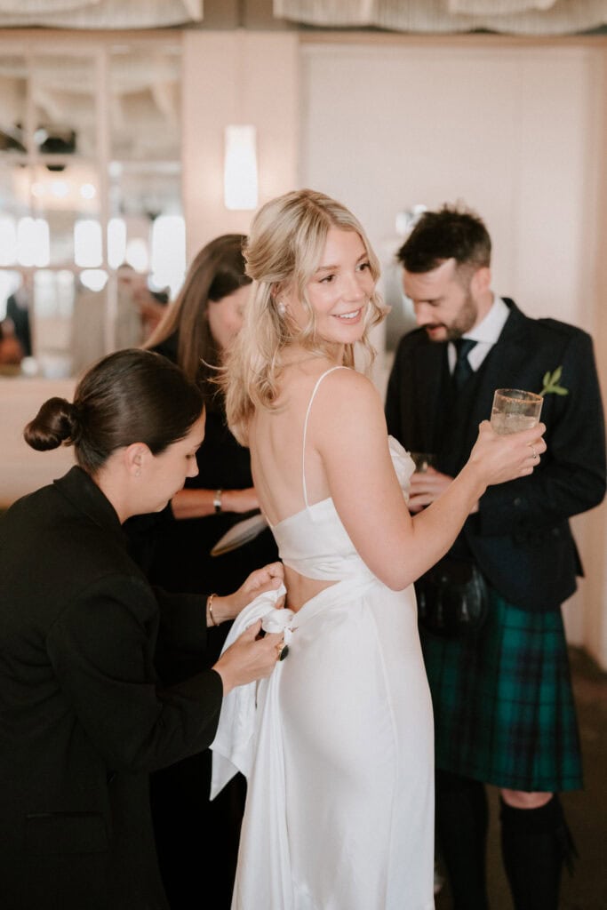 Bride getting ready with her dress adjusted.