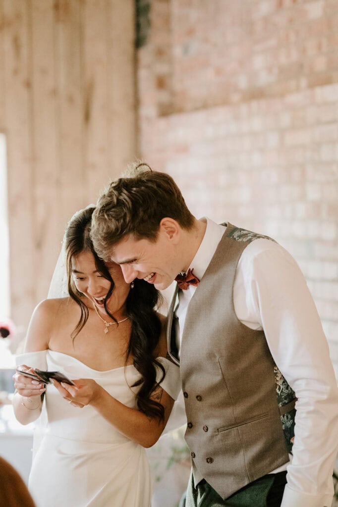 Happy couple looking at their wedding photo previews during wedding reception