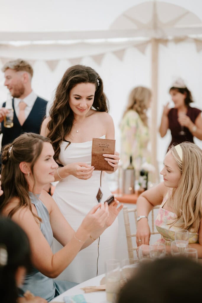 Wedding guests exchanging photos at reception table.