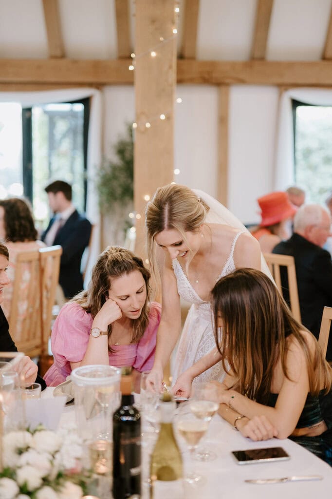 Bride talking with guests at wedding reception table showing the same day wedding prints
