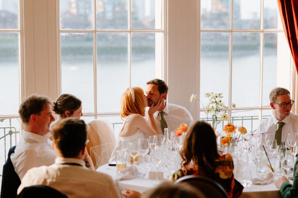 Wedding couple kissing during london reception dinner at the trafalgar tavern