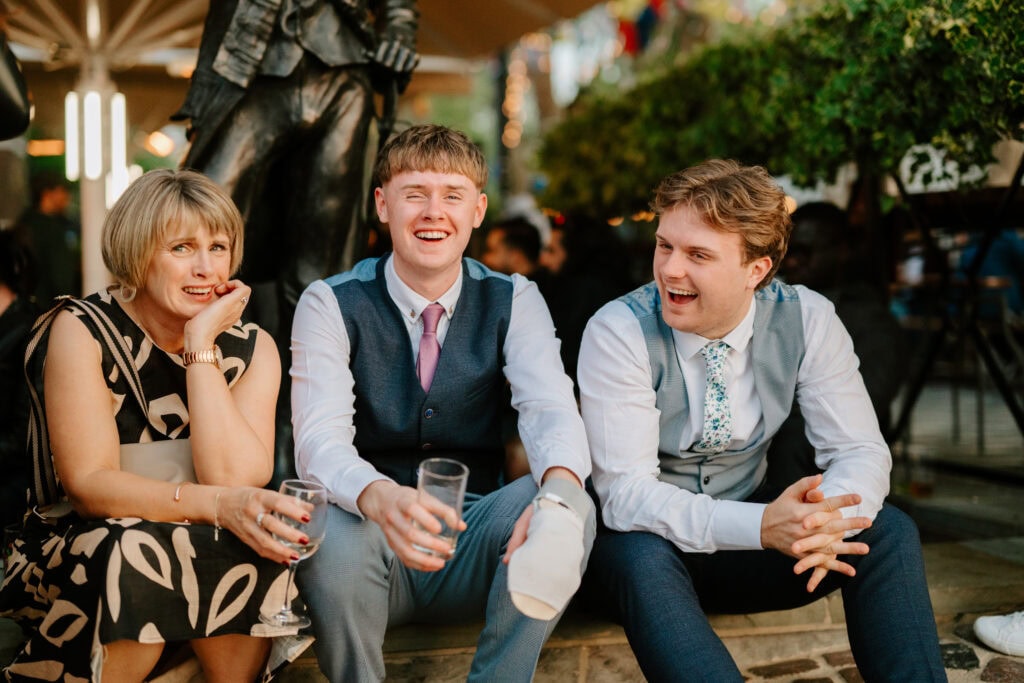 Smiling people sitting outdoors, holding drinks