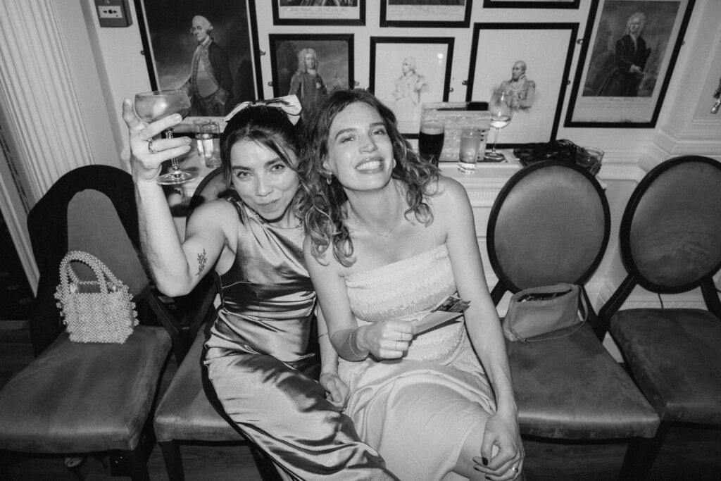 Two women smiling and celebrating indoors.
