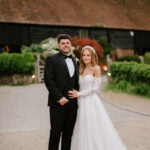 Bride and groom smiling outside rustic barn