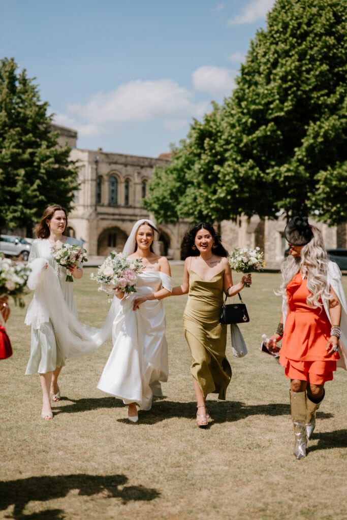 Bride and bridesmaids walking on a sunny day.