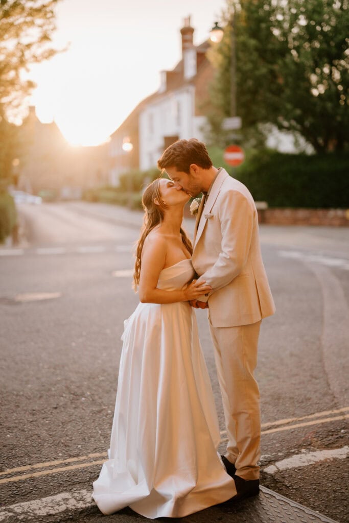 Bride and groom kissing at sunset on canterbury street.