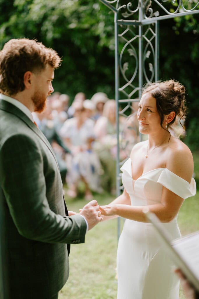 Couple exchanging vows at outdoor wedding ceremony.