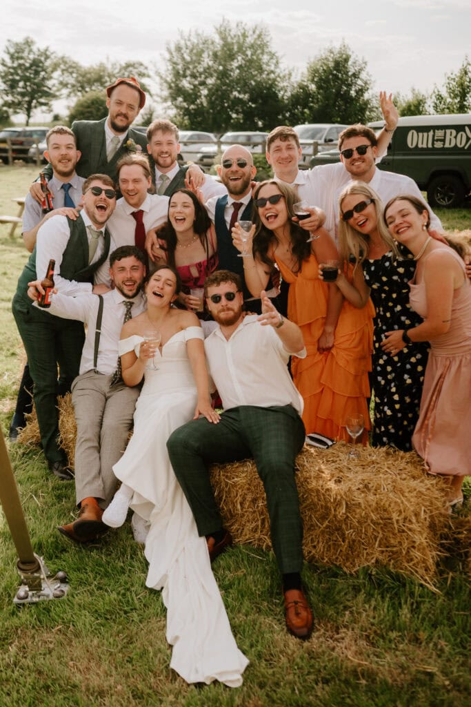 Group celebrating at outdoor wedding, laughing together.