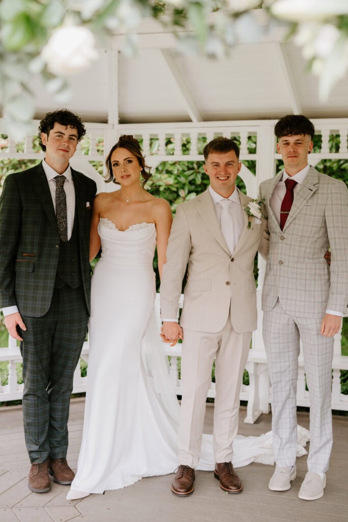 Group portrait at wedding in garden gazebo
