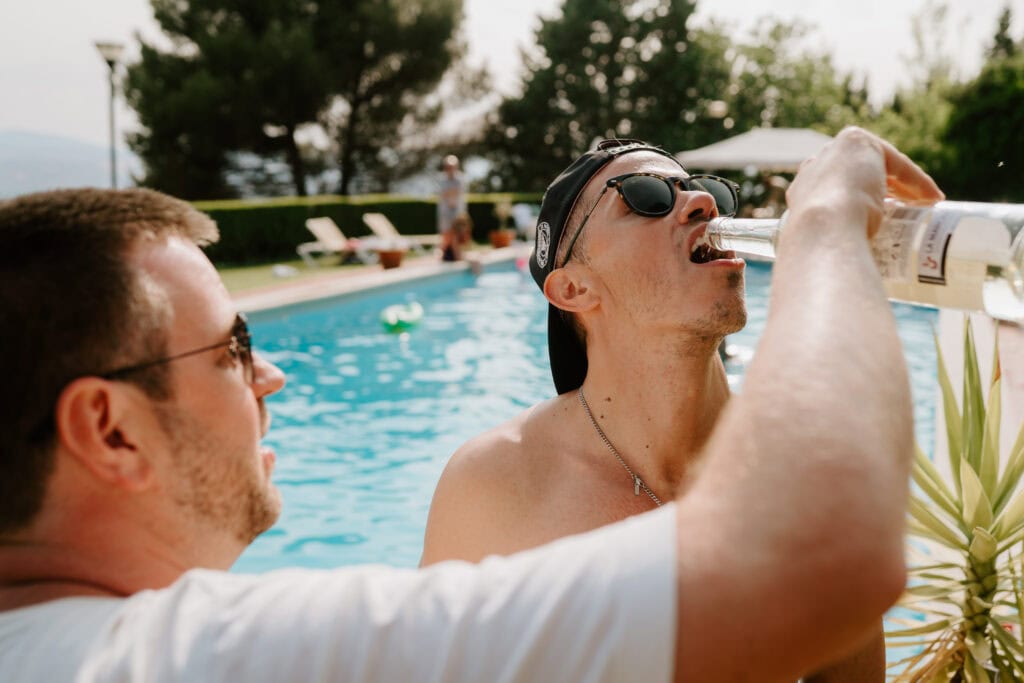 Friends enjoying drinks by the poolside in granada spain during a wedding reception