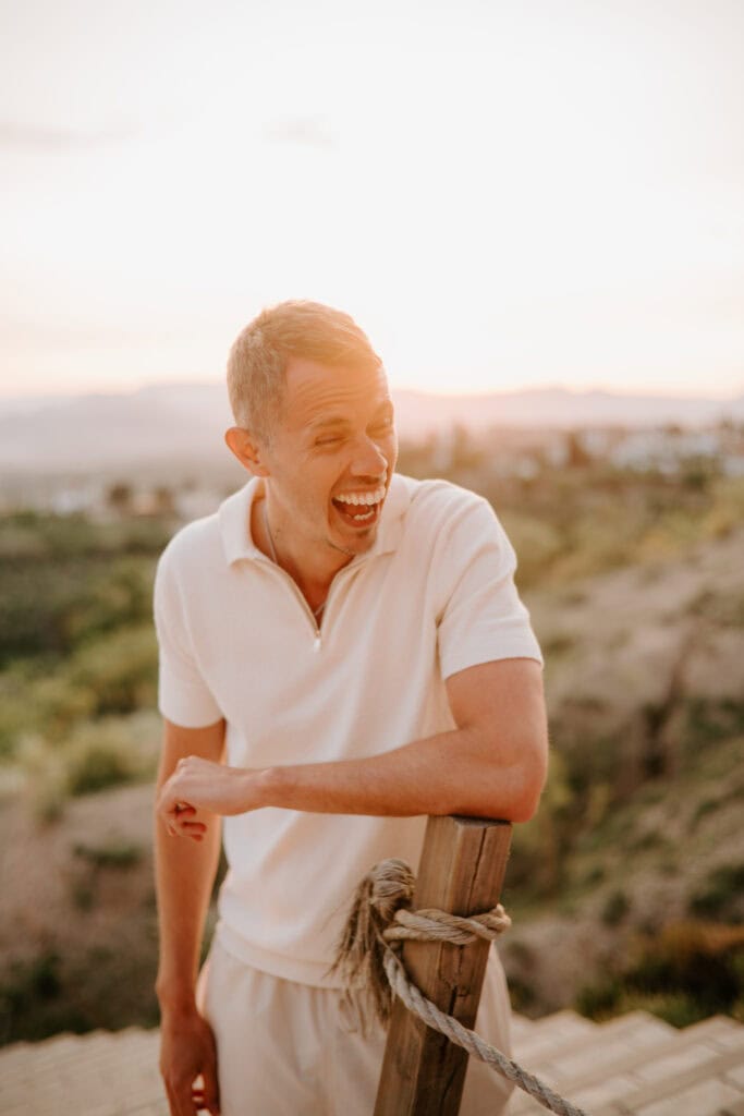 Smiling person enjoying sunset outdoors.