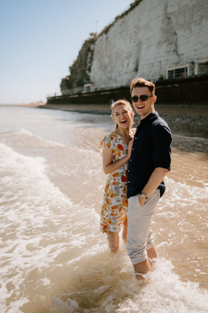Happy couple laughing at the beach