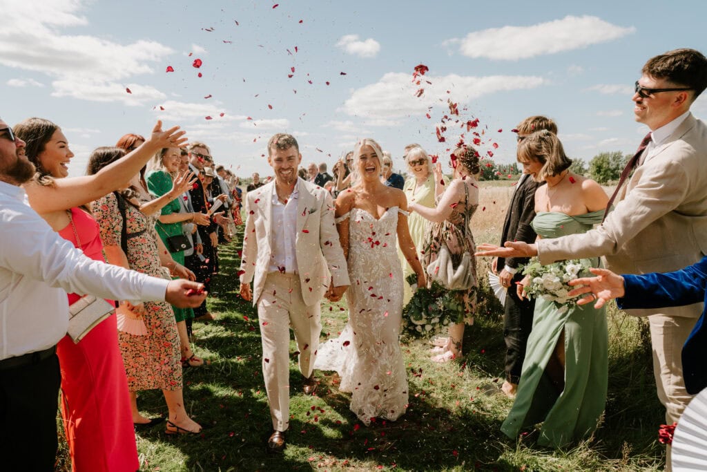 Bride and groom celebrate outdoors with guests.