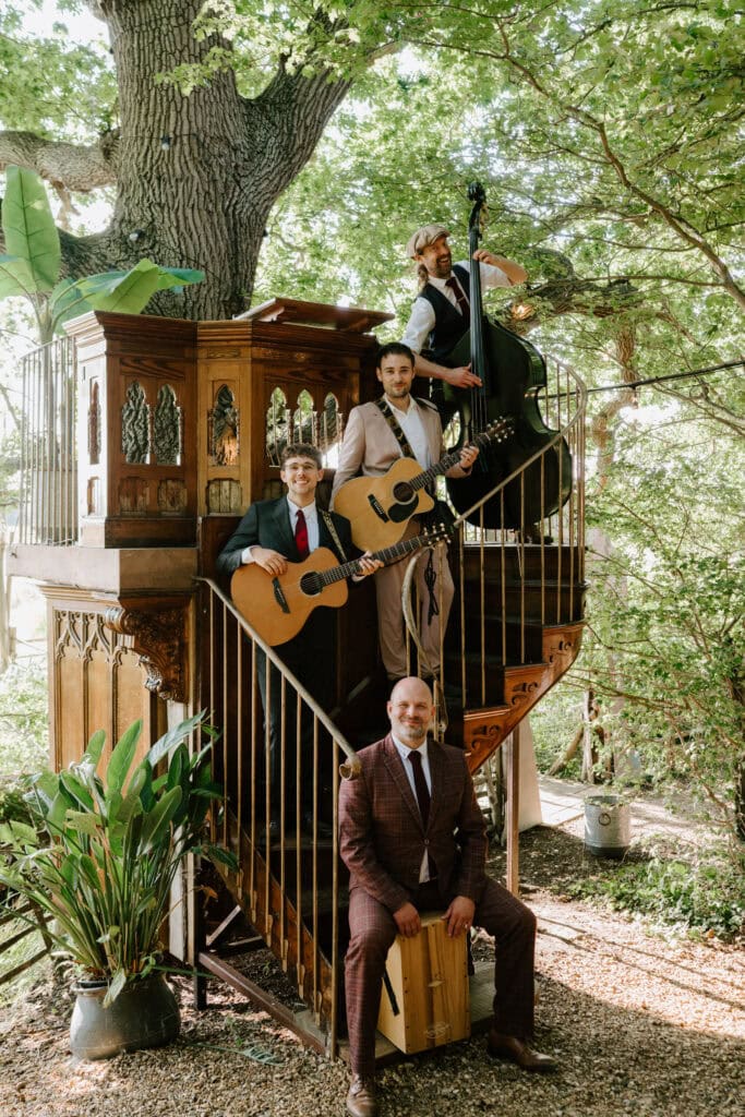 Musicians playing instruments on a staircase outdoors at wilderness weddings kent