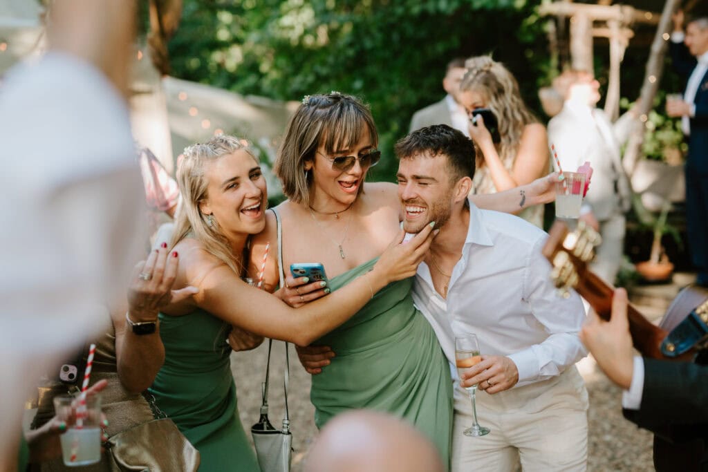 Friends celebrating at outdoor event with drinks.