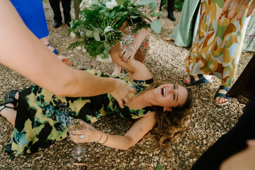 Woman laughing on ground at outdoor event.