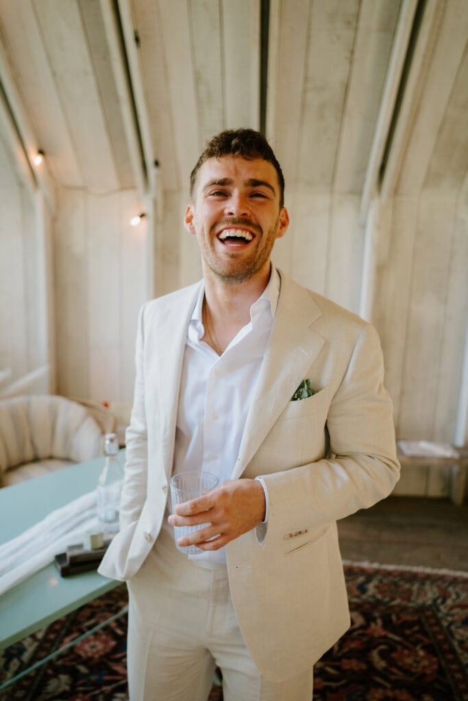 Man in beige suit smiling indoors