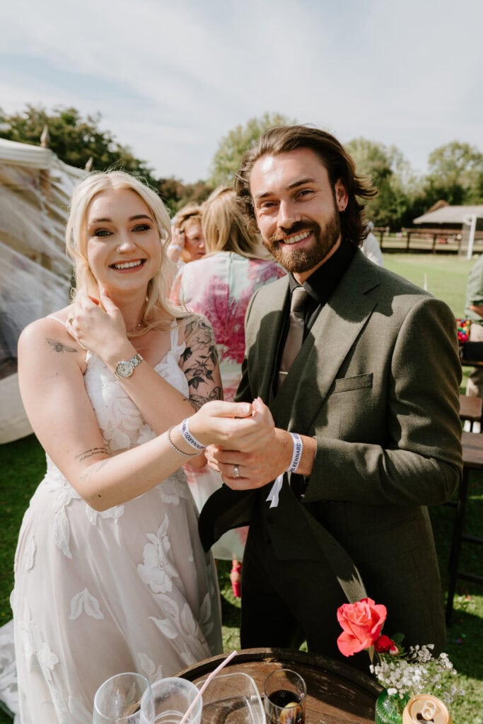 Smiling couple at outdoor wedding ceremony.