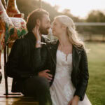 Couple sitting on merry-go-round at sunset