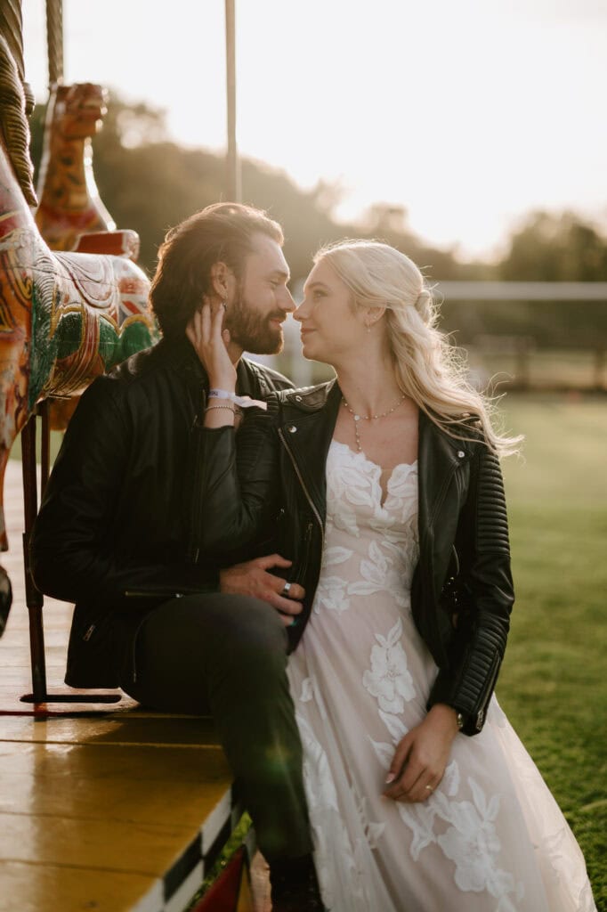 Couple sitting on merry-go-round at sunset