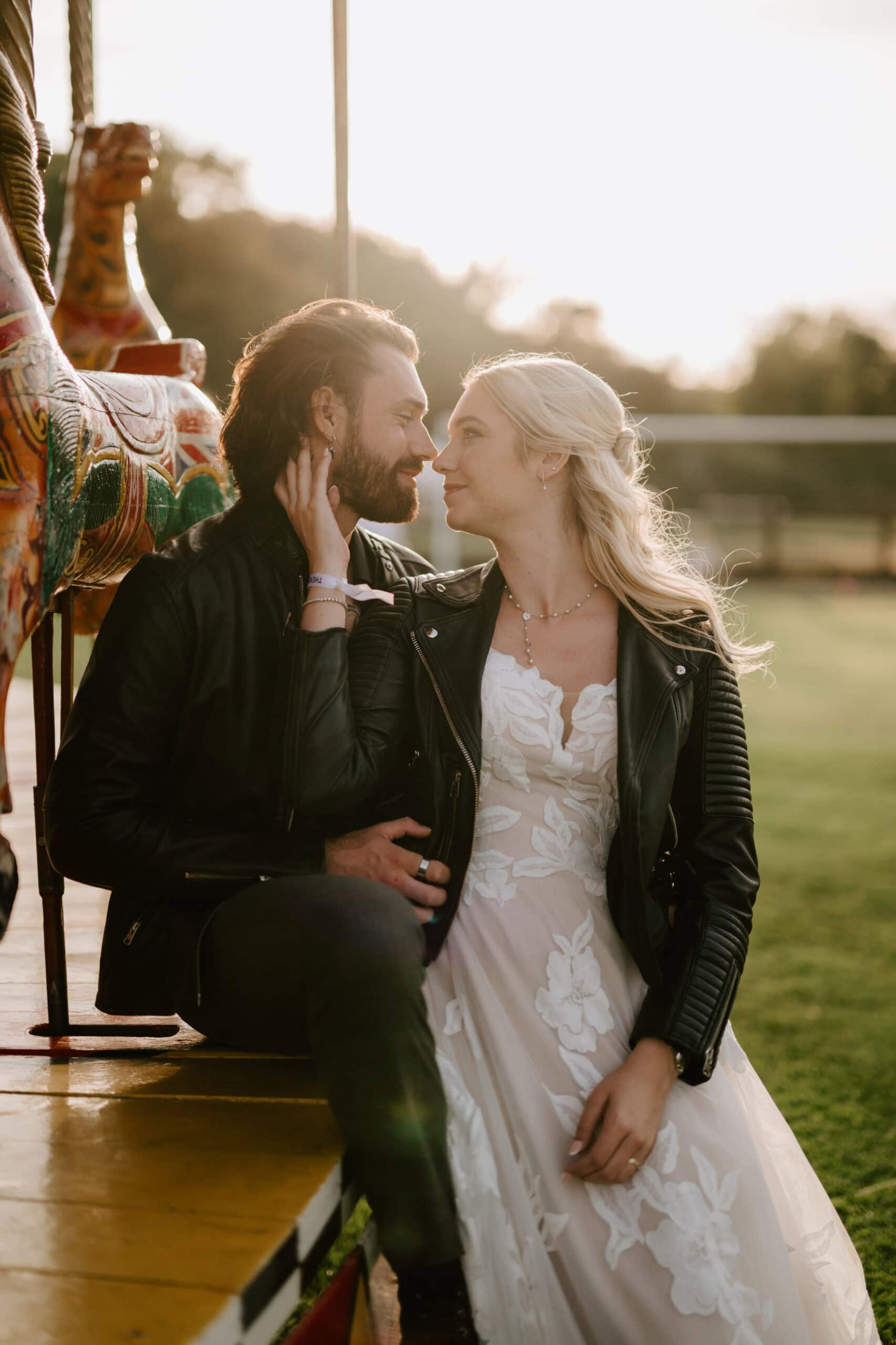 Couple embracing on vintage carousel at sunset.