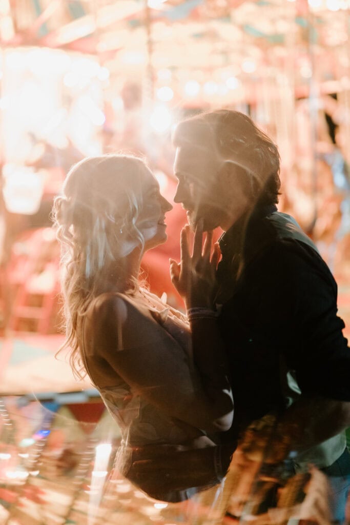 Romantic couple at a carnival, soft warm lights.
