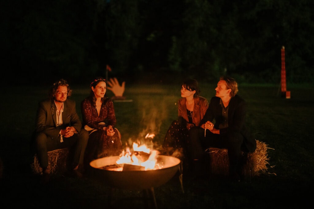 Group gathered around a campfire at night.