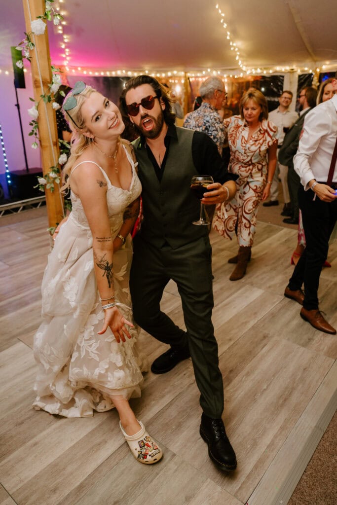 People dancing joyfully at a wedding reception.