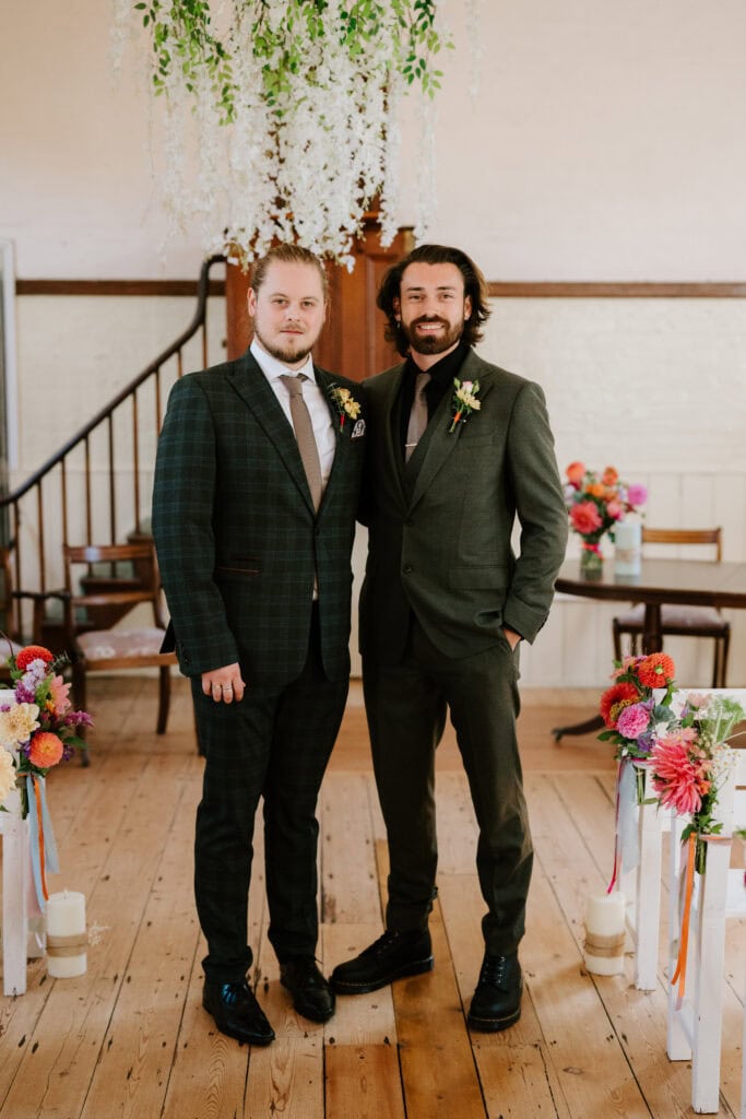 Two grooms posing at their wedding ceremony.