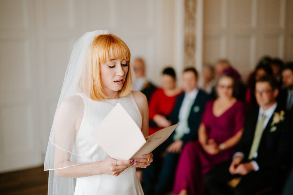 Bride reading vows at wedding ceremony