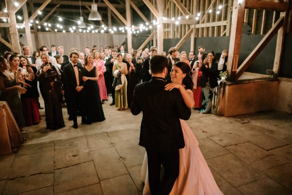 Couple dancing at wedding reception in rustic barn.