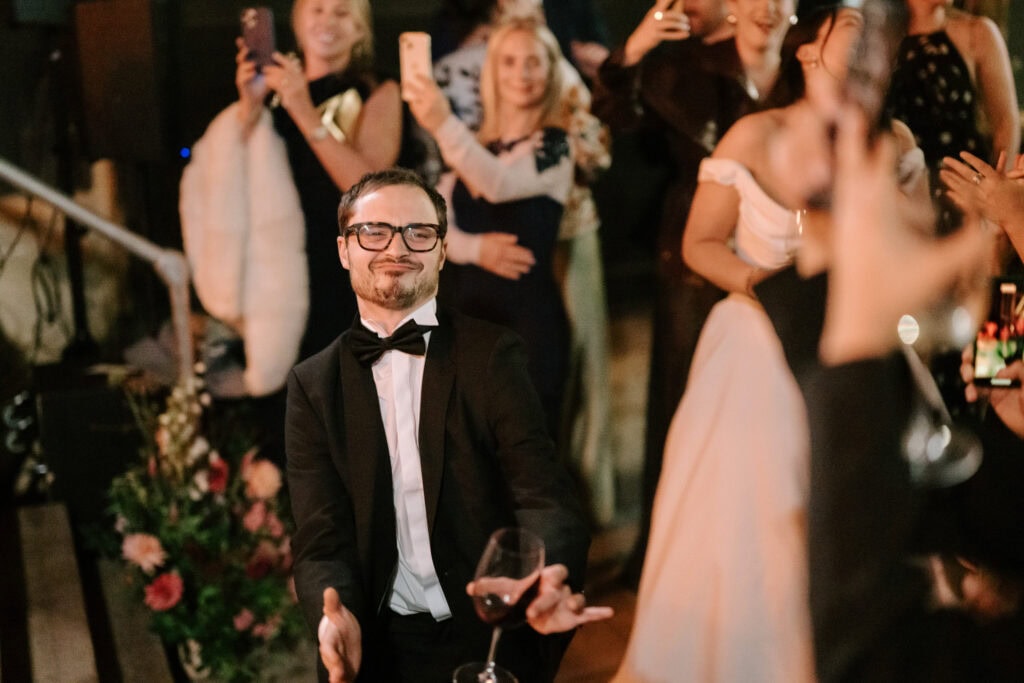 Man in tuxedo dancing at a party.