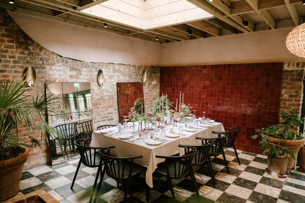 Cosy dining room with set table and plants.