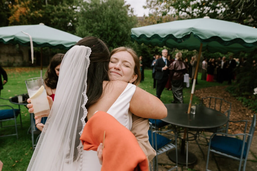 Wedding guests hugging at outdoor reception